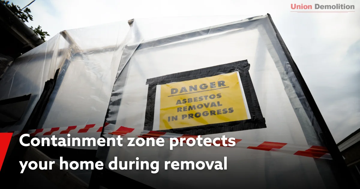 Containment tent with sign warning about asbestos removal inside.